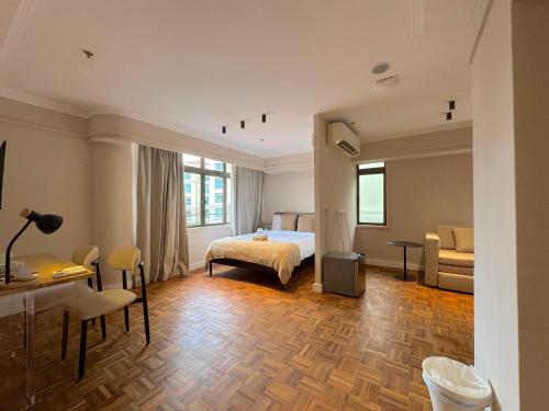 a bedroom with a bed and a table and chairs at The Keystone Clarke Quay in Singapore