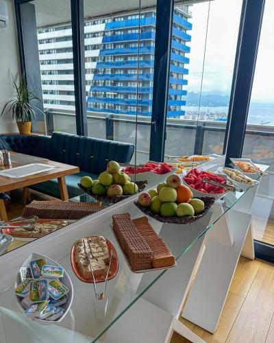 ein Tisch mit mehreren Tellern mit Essen darauf in der Unterkunft Panorama Sea View Central Hotel Batumi in Batumi