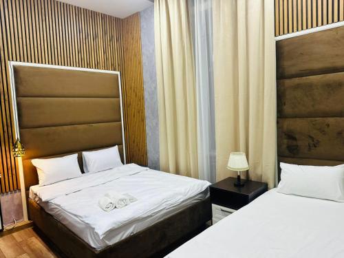 Un dormitorio con dos camas con sábanas blancas. en City Inn Boutique Hotel, en Baku
