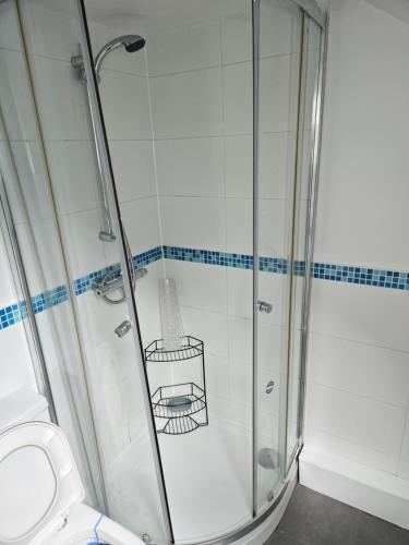 una ducha con puerta de cristal en un baño en The coach house, en Nottingham