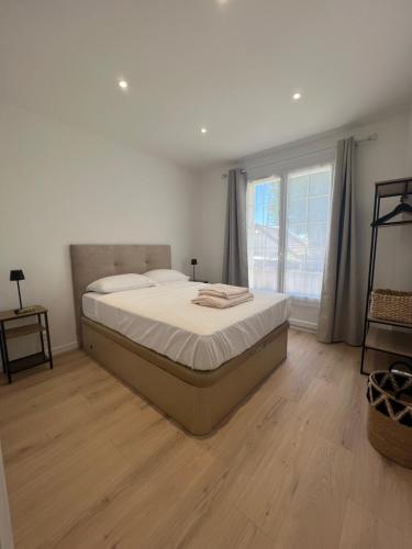 a bedroom with a large bed and a large window at Entre prairies et ciel bleu chez Nicolas ! in Mauchamps