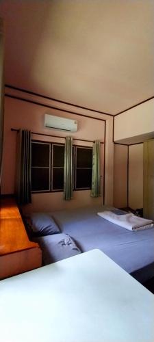 a bedroom with two beds and two windows at Babazia Community in Pai