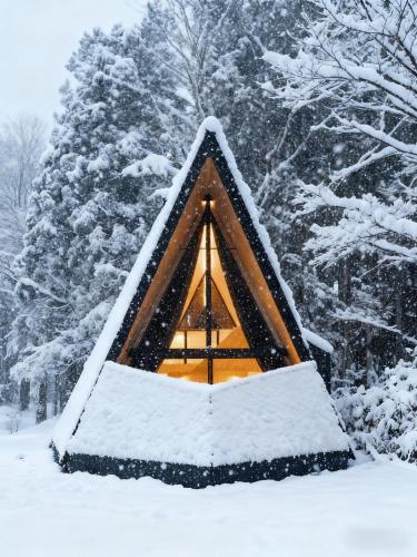 a tree house in the snow in front of a forest at Kokage Villa Nikko-KVN in Nikko