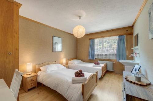 a hotel room with two beds and a sink at Hébergement l'Escale - Le Châble - Verbier in Le Châble