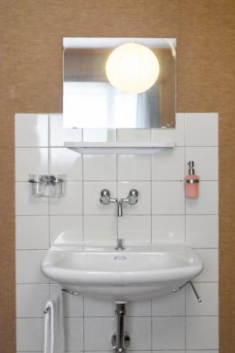 a white bathroom with a sink and a mirror at Hébergement l'Escale - Le Châble - Verbier in Le Châble