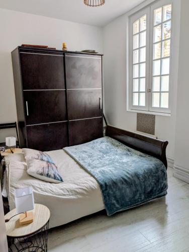a bedroom with a large bed with a wooden headboard at La Clef des Remparts in Chinon