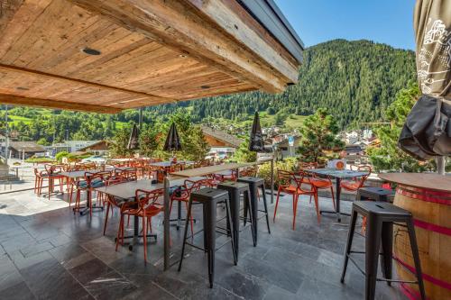 a restaurant with tables and chairs on a patio at Hébergement l'Escale - Le Châble - Verbier in Le Châble