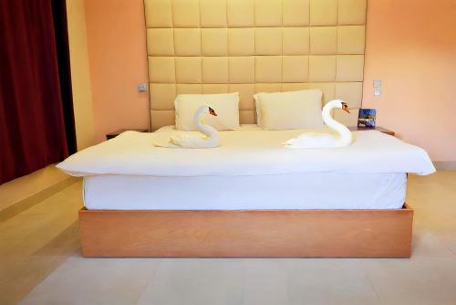 two swans on a bed in a room at Pyramids Grand View Hotel in Cairo