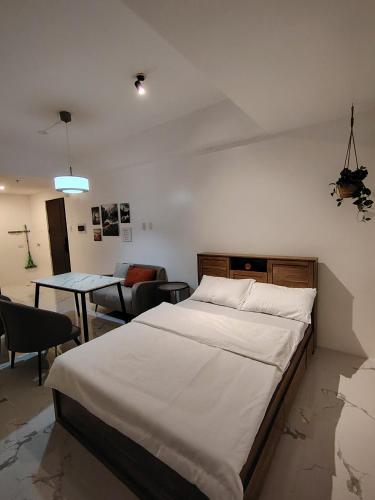 マニラにあるThe Stonecast Residencesの大きなベッドとテーブルのある寝室