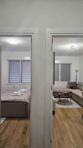 a bedroom with a bed and a living room at Dana in Banja Luka