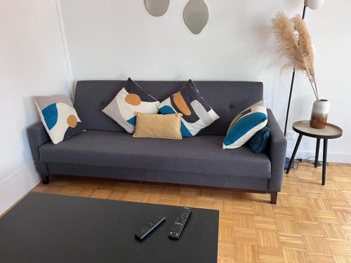 a living room with a gray couch with pillows at Appartement cozy et spacieux in Amiens