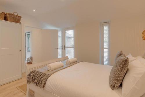 a white bedroom with a large bed and windows at 4 Bed in Lobb oc-s33517 in Georgeham