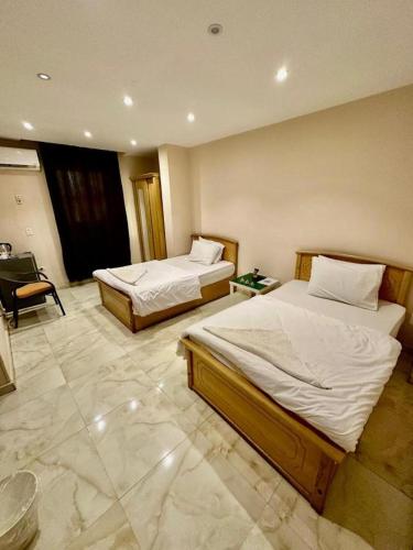 a room with two beds and a chair in it at Pyramids Grand View Hotel in Cairo