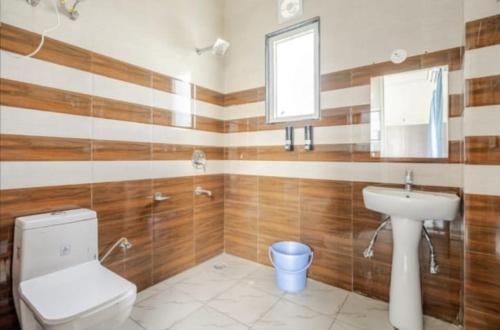 a bathroom with a toilet and a sink at The Royal Harmony in Greater Noida