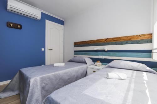 deux lits dans une chambre aux murs bleus dans l'établissement Apartment TOUS 2 - Only Families, à Salou