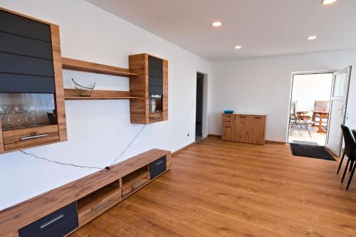 a living room with a tv and wooden floors at Ferienwohnung Zirbitzblick in Fohnsdorf