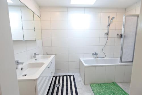 a white bathroom with a sink and a shower at Ferienwohnung Zirbitzblick in Fohnsdorf
