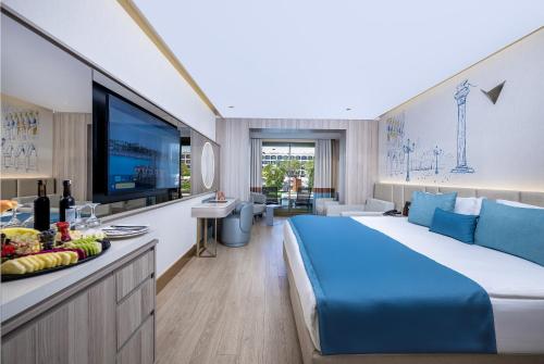 a hotel room with a large bed and a flat screen tv at Ducale Lara - Ultra All Inclusive in Lara