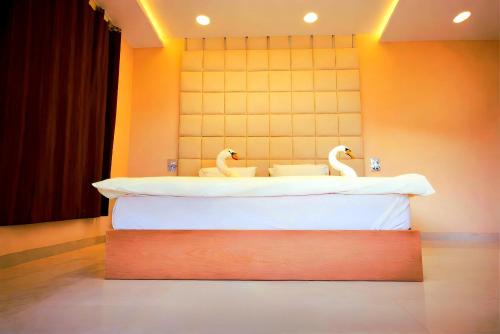 two swans sitting on a bed in a room at Pyramids Grand View Hotel in Cairo