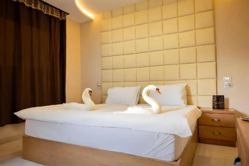 two swans sitting on a bed in a room at Pyramids Grand View Hotel in Cairo