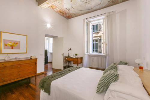 una camera da letto con un grande letto bianco e una finestra di Rome Central Suite via Vittoria a Roma