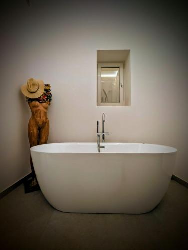 a white bath tub in a bathroom with a hat at Porta di Castro Boutique Hotel & Pool in Palermo