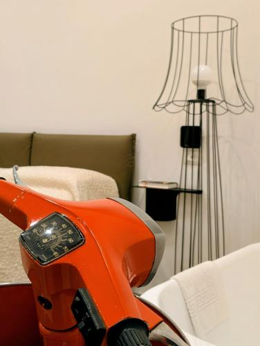 an orange scooter parked in a room with a bed at Porta di Castro Boutique Hotel & Pool in Palermo