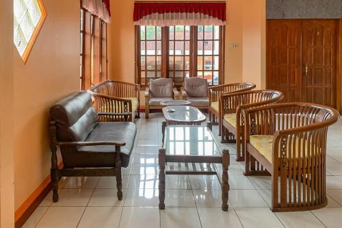 a living room with chairs and a table and a couch at RedDoorz near Taman Wisata New Balekambang Tawangmangu in Karanganyar