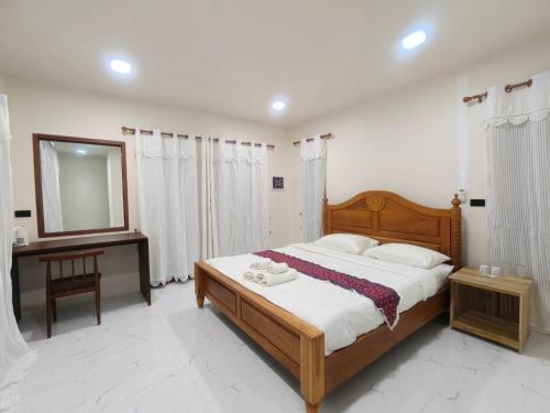 a bedroom with a bed and a mirror and a desk at WC Coffee&ไร่หวานซึ้ง in Mae Hong Son