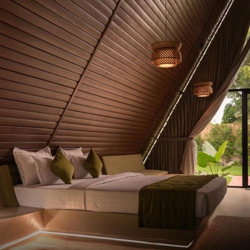 una cama en una habitación con techo de madera en Serene Fields Retreat, en Kanāria