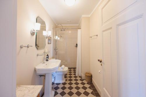 a white bathroom with a sink and a toilet at Aarøsund Badehotel in Haderslev