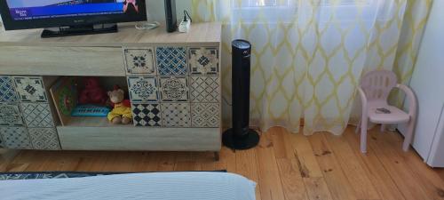 Un dormitorio con una cómoda con un televisor y una varita. en Daniela House, en Caneças