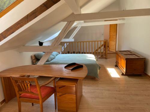 a room with a table and a bed in a attic at Petite maison SOUS LE TILLEUL in Schiltigheim