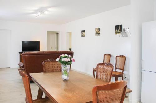 a dining room table with a vase of flowers on it at Renovated 2-bedroom apartment in Drancy