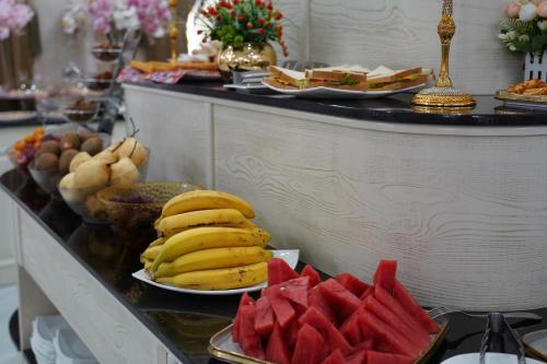 ein Buffet mit Bananen und Wassermelonen auf einem Tisch in der Unterkunft Shaxzoda Elite Hotel in Samarkand