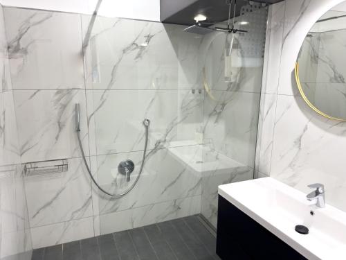 a white bathroom with a shower and a sink at Birdsong Apartment in Oubaai Golf Estate in Herolds Bay