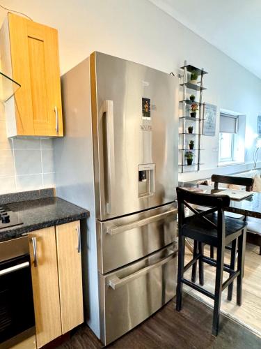 a kitchen with a stainless steel refrigerator and a table at The Dock, South Shields 2 bedrooms sleeps 5 long stay and contractor rates welcome in South Shields