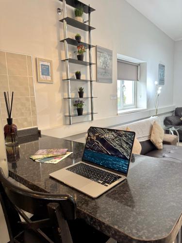 a laptop computer sitting on a table in a living room at The Dock, South Shields 2 bedrooms sleeps 5 long stay and contractor rates welcome in South Shields
