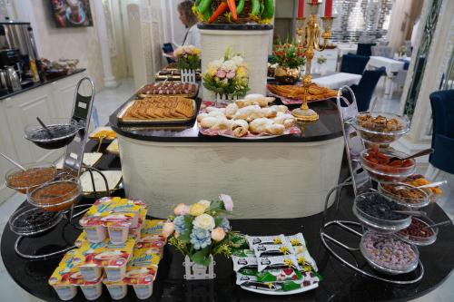 ein Buffet mit Speisen auf einem Tisch in einem Laden in der Unterkunft Shaxzoda Elite Hotel in Samarkand
