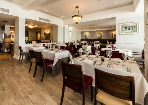 a dining room with white tables and chairs at The Old Ship Hotel in Brighton & Hove