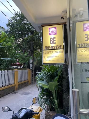 une moto garée devant un magasin avec des panneaux dans l'établissement Homestay Be, à Hue