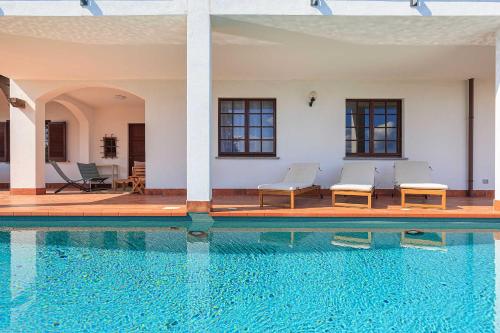 a swimming pool with chairs and a house at Welcoming villa with pool & views! - Villa Mirella in Dagnente