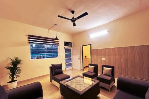 Una sala de estar con un sofá y un ventilador de techo. en Embassy Loagde Inn, en Mussoorie