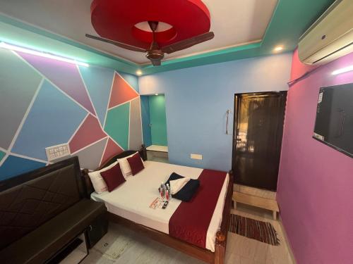 Una pequeña habitación con una cama y un televisor. en Panmozhi residency, en Tiruvannāmalai