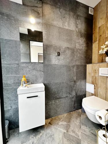 コシツェにあるDMR APARTMENTS Central GOLDの白い洗面台とトイレのあるバスルーム
