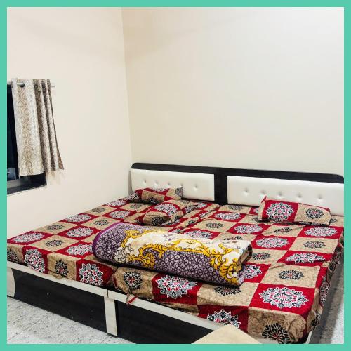 a bed with a quilt and pillows on it at Hotel Khatoo Shyam House in Khātu