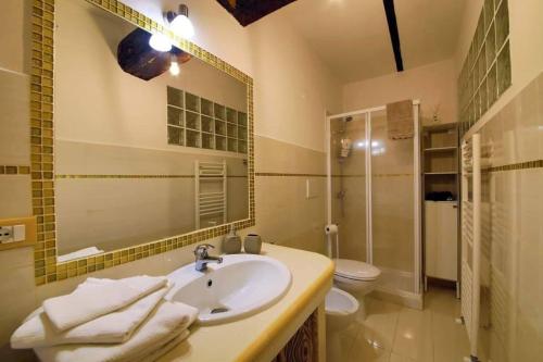 a bathroom with a sink and a toilet and a mirror at Il Vicolo Incantato in Fondi