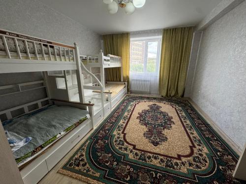 ein Zimmer mit zwei Etagenbetten und einem Teppich in der Unterkunft 3х комнатная квартира in Öskemen