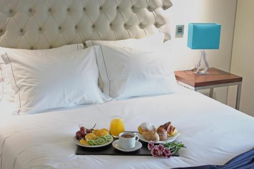 un vassoio con prodotti per la colazione su un letto di Casa do Passal Country House a Paço de Sousa