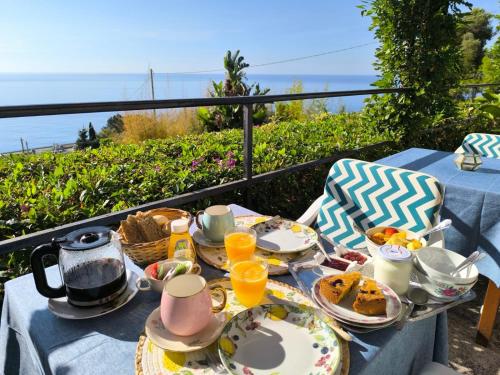 a table with plates of breakfast food on a balcony at Gli Orti sul mare 1 Vista mare in Bordighera